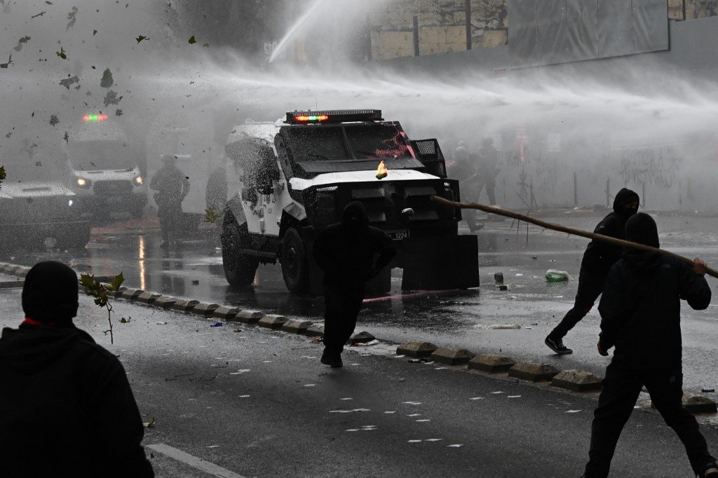 在智利圣地牙哥的劳动节抗议活动中，蒙面示威者与防暴警察发生冲突。（图取自法新社）